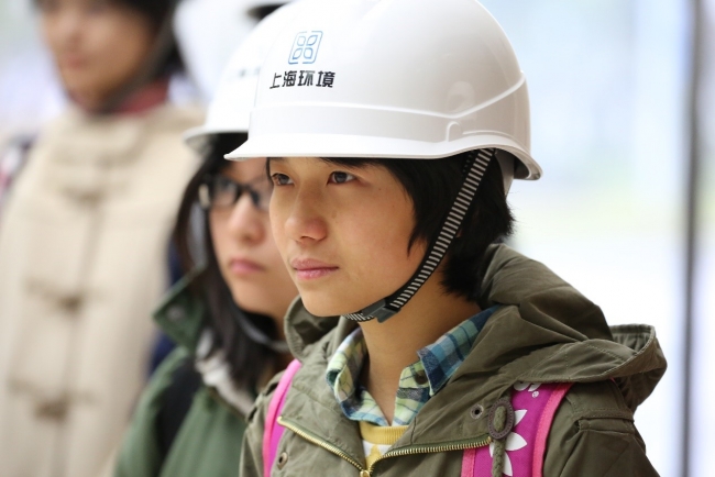 老港再生能源利用中心一楼大厅，戴防护用具的同学们2